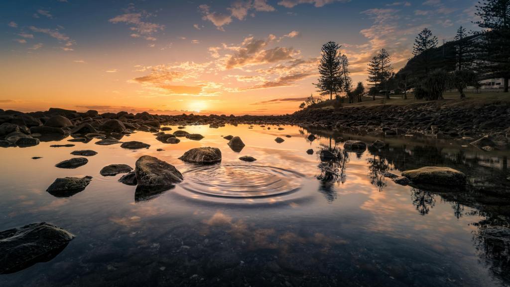 sunset over a rocky pond
